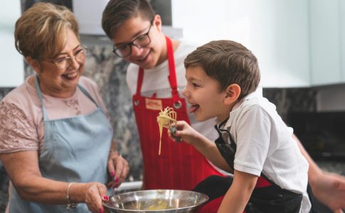 Un jeune garçon tenant un fouet lors d'un atelier cuisine mis en place par la Semaine du Goût 2024.