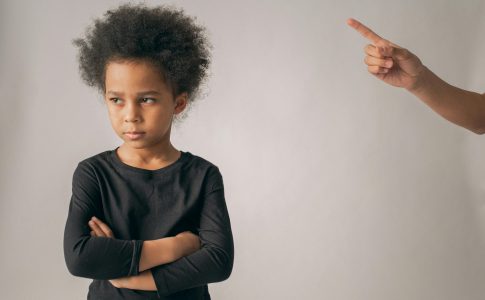 Un parent qui réprimande son enfant en pointant le doigt.