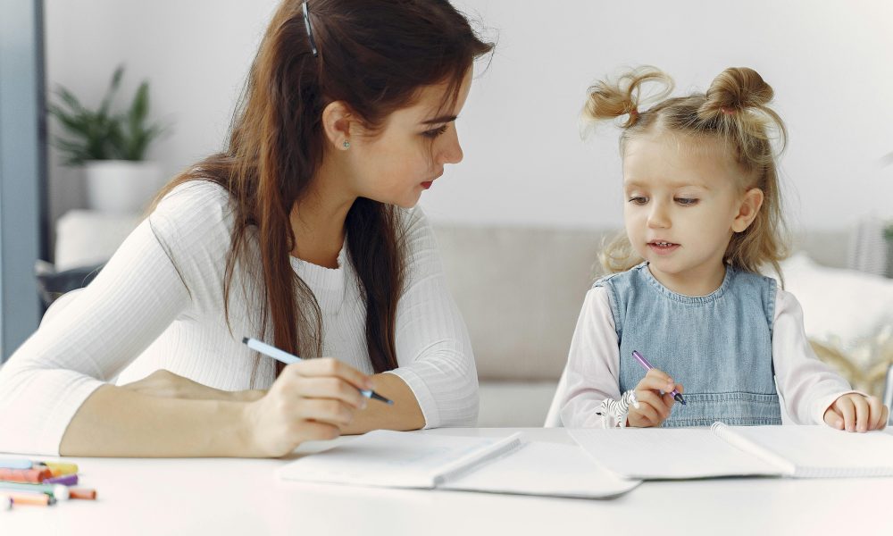 Une psychomotricienne apprenant à une enfant à dessiner, un métier célébré lors de la Journée européenne de la psychomotricité.