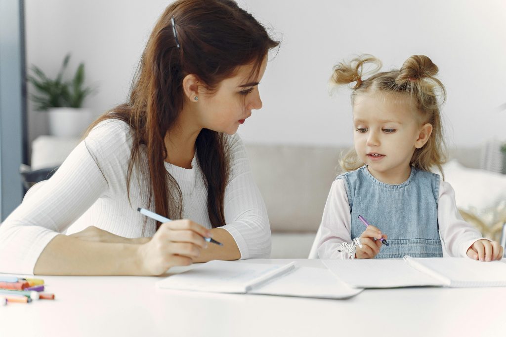 Une psychomotricienne apprenant à une enfant à dessiner, un métier célébré lors de la Journée européenne de la psychomotricité.