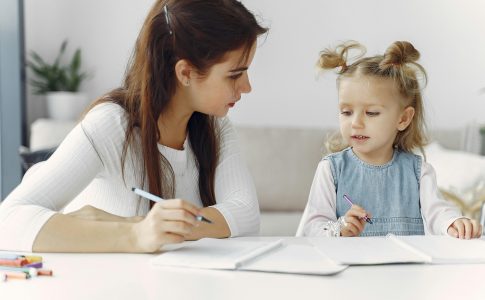 Une psychomotricienne apprenant à une enfant à dessiner, un métier célébré lors de la Journée européenne de la psychomotricité.