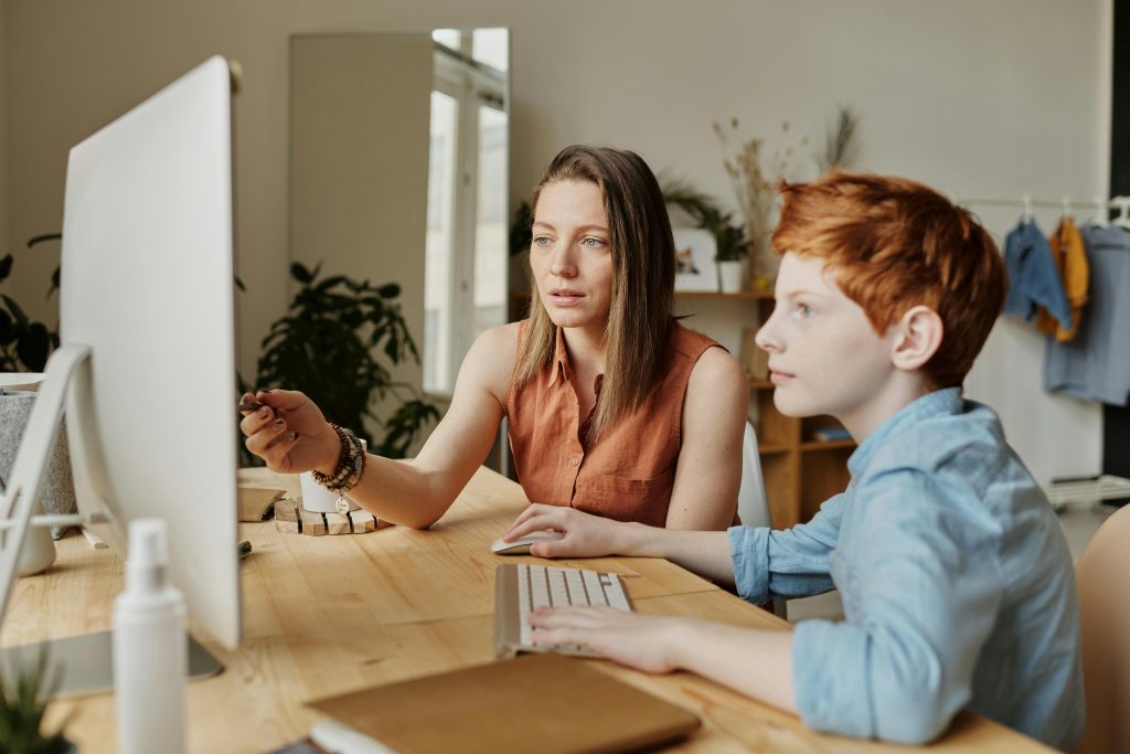 Une femme enseignant la cybersécurité à un enfant, illustrant les bonnes pratiques numériques.