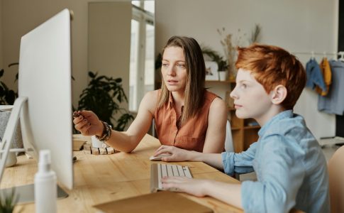 Une femme enseignant la cybersécurité à un enfant, illustrant les bonnes pratiques numériques.