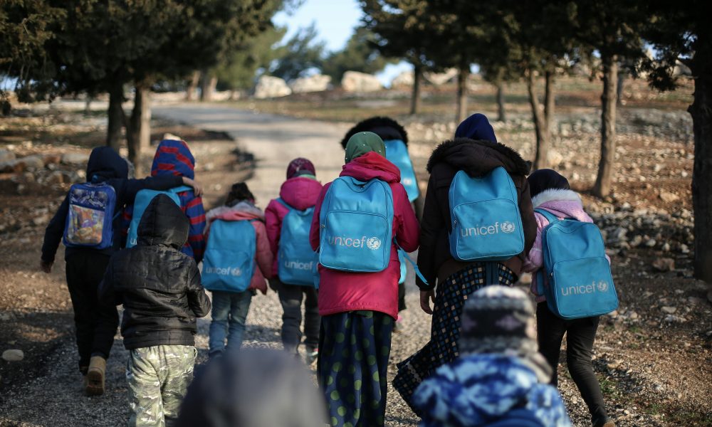 Des enfants marchant avec des sacs à dos UNICEF.