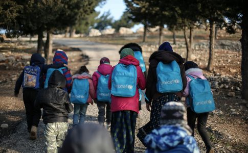 Des enfants marchant avec des sacs à dos UNICEF.