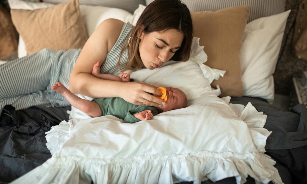 Une mère donnant une tétine à son bébé en pleurs.