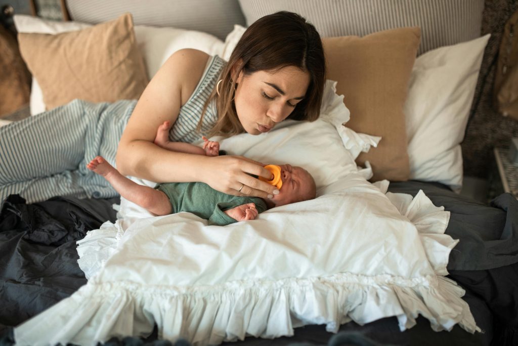 Une mère donnant une tétine à son bébé en pleurs.