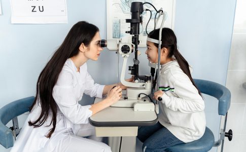 Un médecin effectuant un examen visuel sur une enfant.