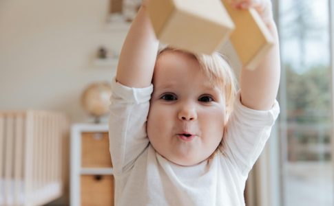 Bébé jouant avec des blocs en bois, dans sa chambre.