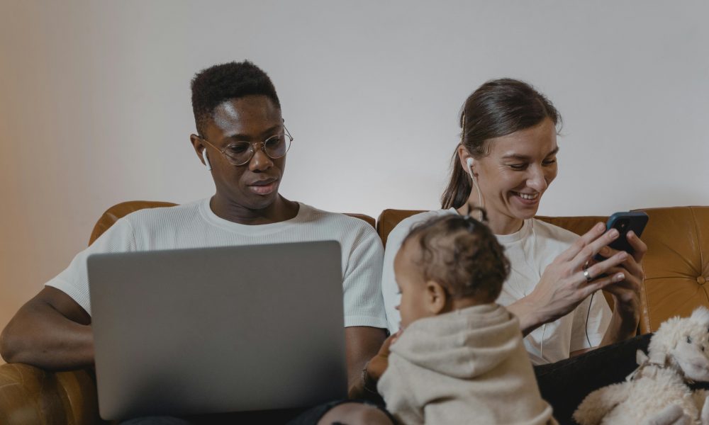 Des parents absorbés par leurs téléphones portables, chacun sur une activité différente, pendant un moment en famille.