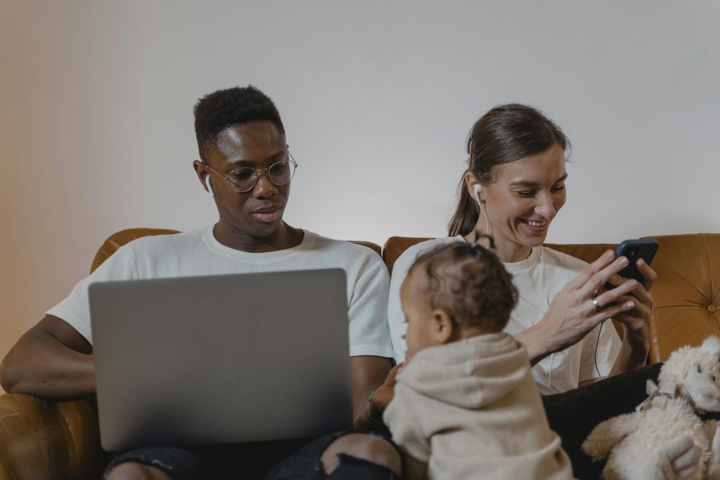 Des parents absorbés par leurs téléphones portables, chacun sur une activité différente, pendant un moment en famille.