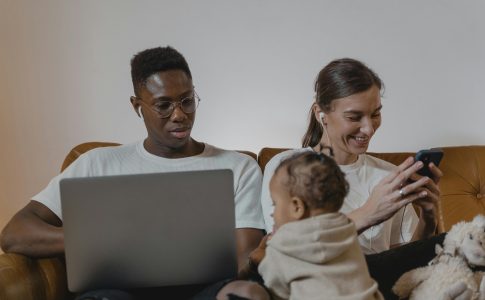 Des parents absorbés par leurs téléphones portables, chacun sur une activité différente, pendant un moment en famille.