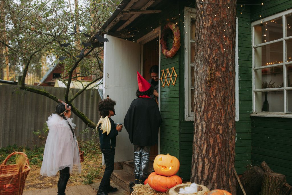 Enfants costumés faisant du porte-à-porte pour collecter des friandises d’Halloween.