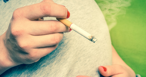 Une femme enceinte en train de fumer de la cigarette