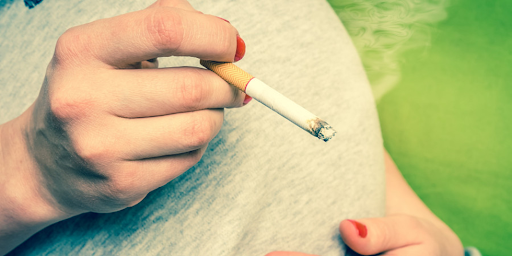 Une femme enceinte en train de fumer de la cigarette