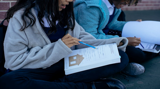 Jeunes élèves diversifiés qui étudient la leçon ensemble dans la cours