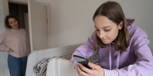 Des enfants utilisant des tablettes et smartphones surveillés par des parents attentifs.