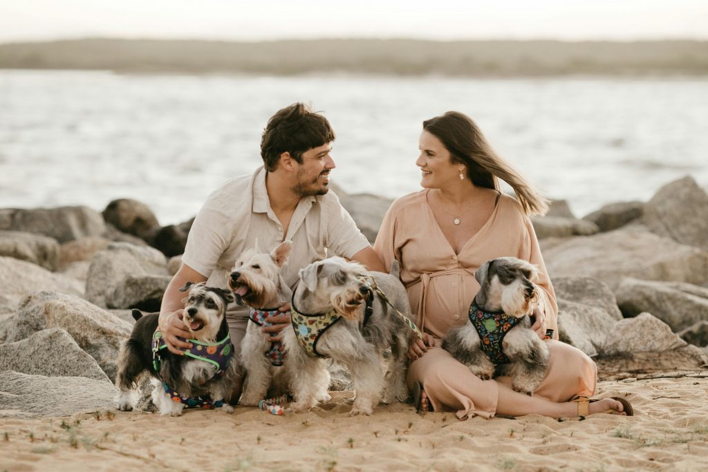 Un couple à la plage avec leurs multiples de chiens.