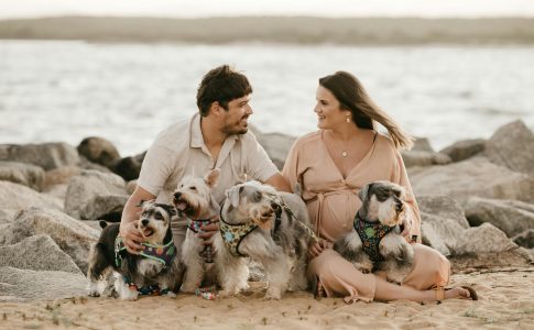 Un couple à la plage avec leurs multiples de chiens.