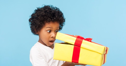 Un enfant heureux ouvre un cadeau de Noël