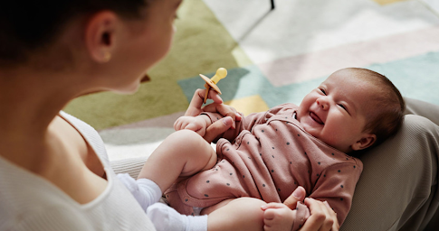 Une mère souriante interagit avec son bébé