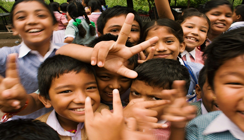 Des enfants souriant en prenant une photo.