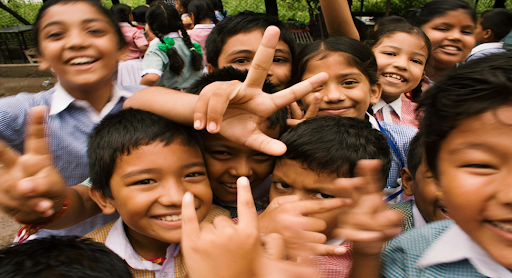 Des enfants souriant en prenant une photo.