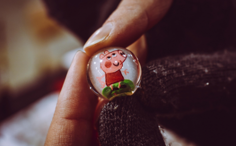 Personne tenant Peppa Pig Toy Marble.