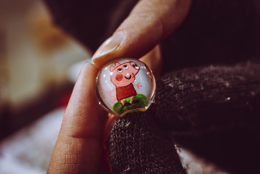 Personne tenant Peppa Pig Toy Marble.