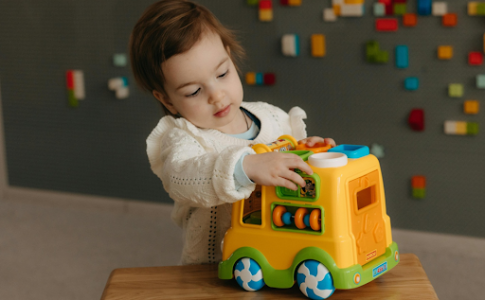 Un enfant jouant une voiture en LEGO.