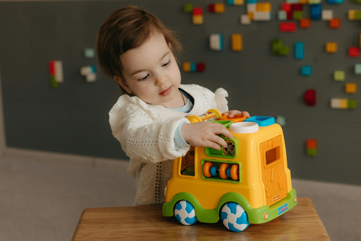 Un enfant jouant une voiture en LEGO.
