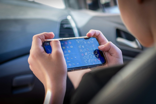 Un jeune en train de jouer sur son smartphone.