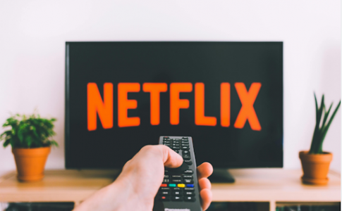 Une personne commandant Netflix sur son écran.