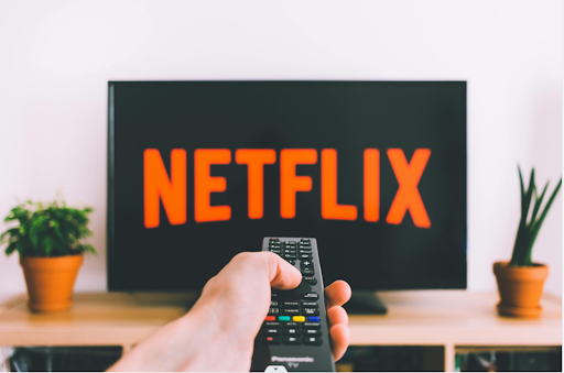Une personne commandant Netflix sur son écran.