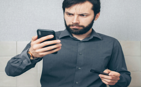 Une personne utilisant sa carte bancaire et son smartphone.