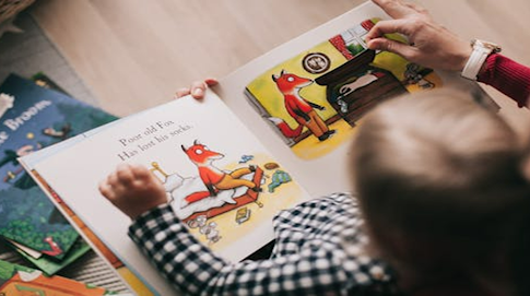 Un enfant en train de lire un livre cartonné.