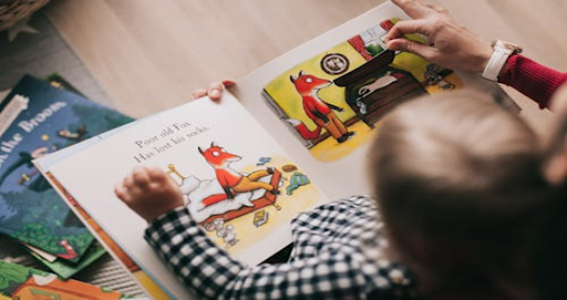 Un enfant en train de lire un livre cartonné.