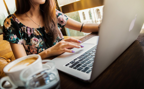Une femme travaillant activement sur son ordinateur portable, chez elle.