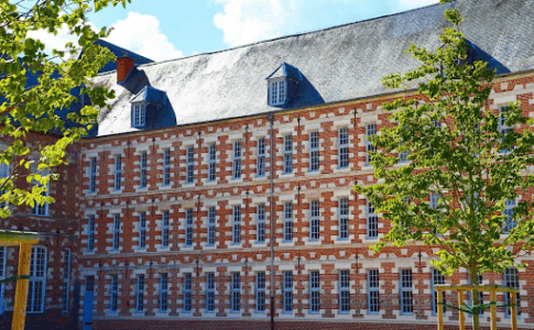 Un grand collège en France sous un ciel bleu.