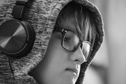 Un jeune garçon à lunettes avec un énorme casque audio vissé sur la tête.