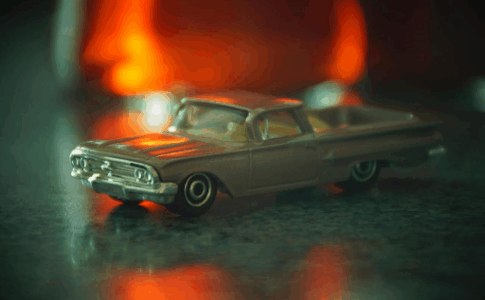 Voiture miniature stylisée posée sur une surface marbrée.