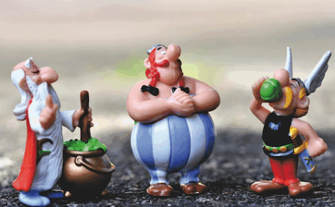 Des figurines d’Astérix, de Panoramix et d’Obélix posées sur le bitume.