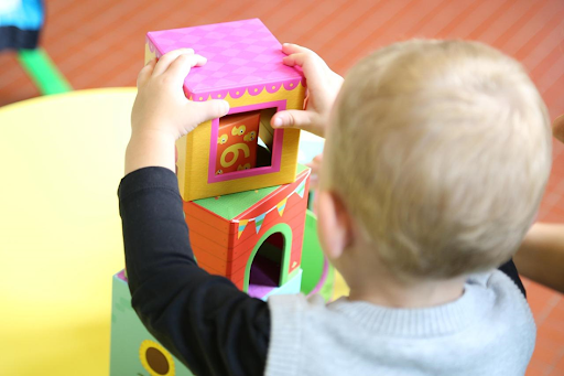 Un jeune bébé en train de jouer à des blocs de bois dans une crèche.