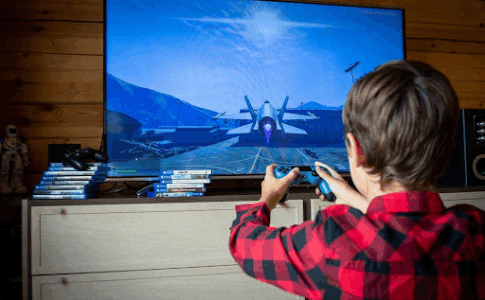 Un jeune garçon en train de jouer à un jeu vidéo sur télévision.
