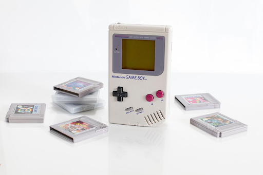 Une console Gameboy entourée de ses cartouches de jeu.