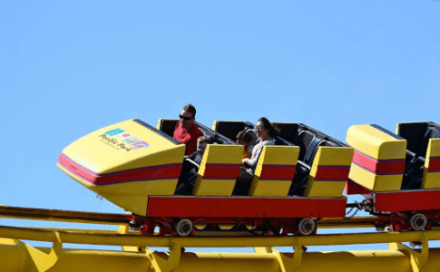 Une famille profitant d’un raid sur le grand huit d’un parc d’attractions.