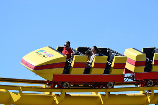Une famille profitant d’un raid sur le grand huit d’un parc d’attractions.