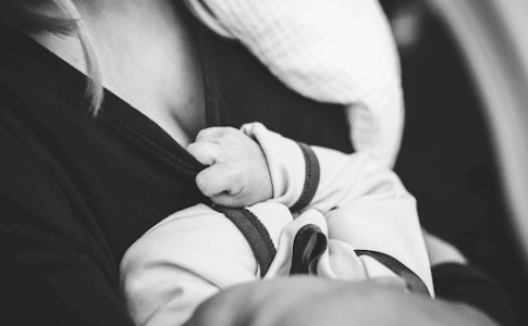 Une image en noir et blanc d’un bébé avec sa mère.