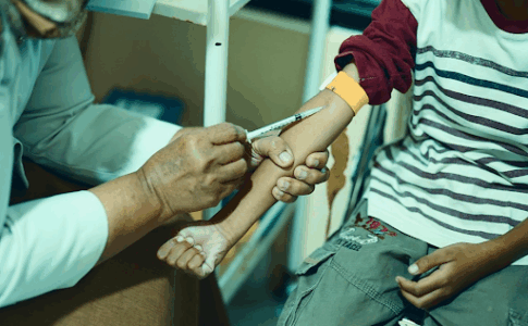 Une infirmière en plein injection de vaccin à un enfant.