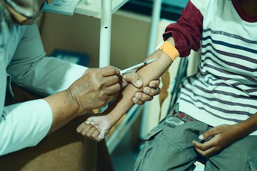 Une infirmière en plein injection de vaccin à un enfant.